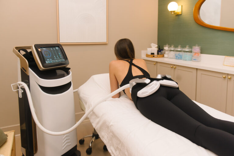 Woman in black undergoing EMS therapy on her lower back part.